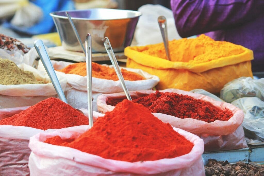 Colorful spice market with vibrant turmeric, chili, and curry powders.