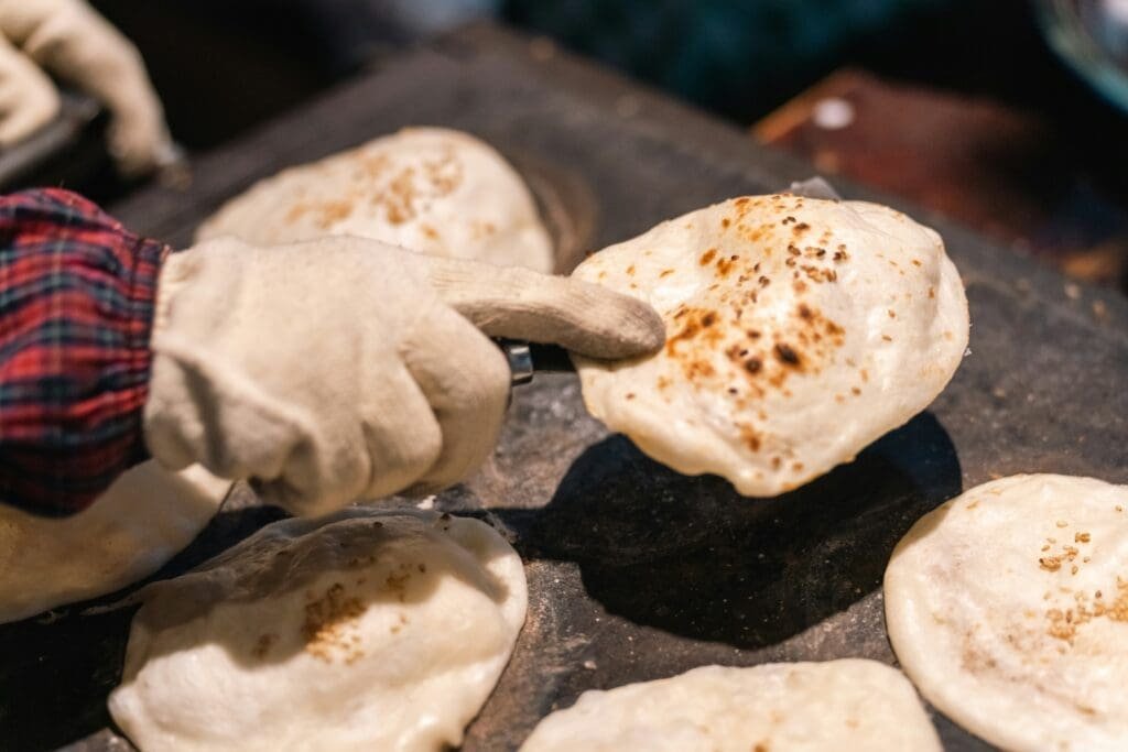 Chapati cooking on a flat pan over open flame in an East Africa street kitchen