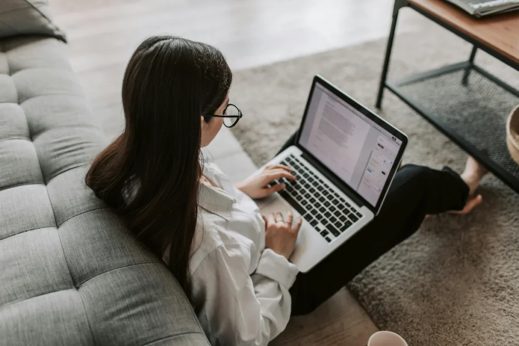 woman sitting on the floor using a laptop for blogging