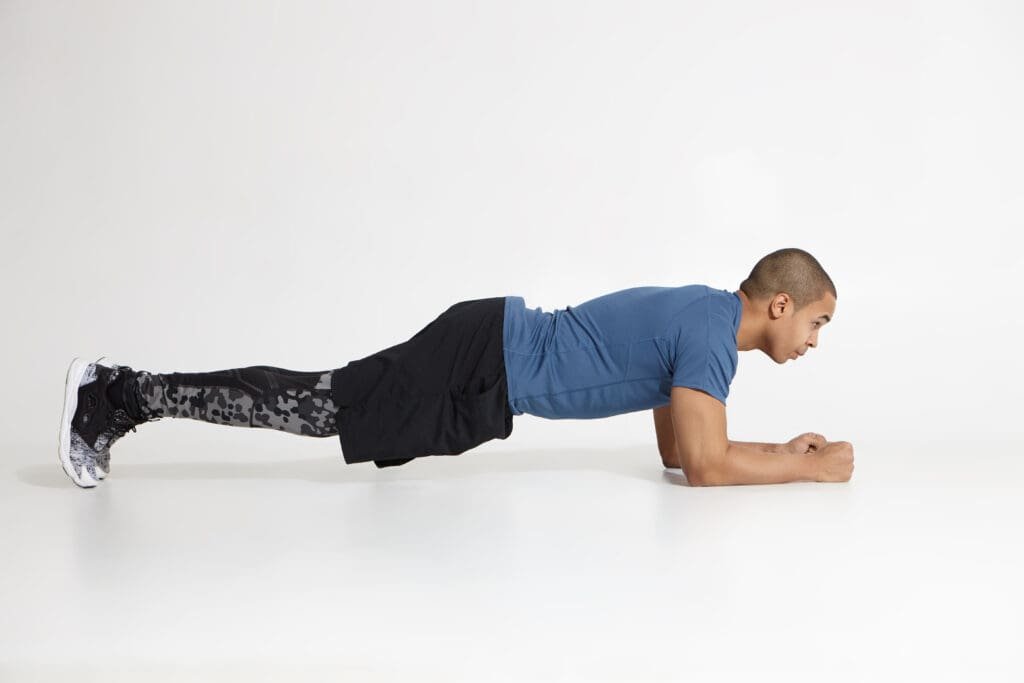 A young man doing a plank hold  strength exercise