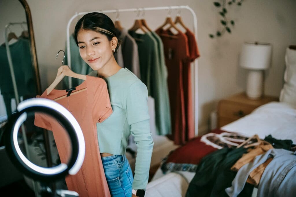 Fashion blogger filming in front of her wardrobe with a ring light, creating styling content.