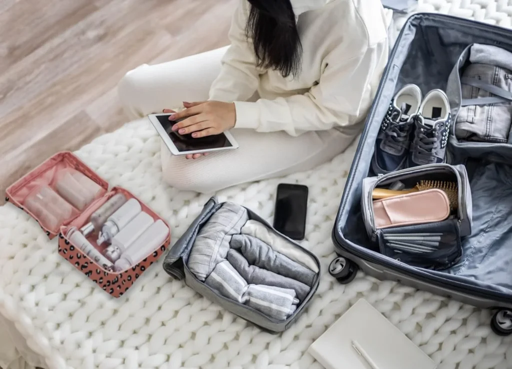 Girl packing a suitcase with travel outfits neatly organized.